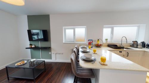 纽波特Stylish Duplex Apartment with Home Office的厨房配有桌椅和台面