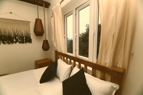 乔奥诺奥尔KACHINS Homes的卧室配有带枕头的床铺和窗户。