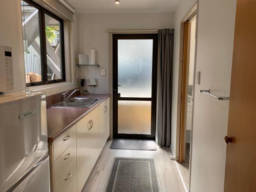 皇后镇瓦卡蒂普湖景公寓的厨房设有通往带水槽的厨房的门。