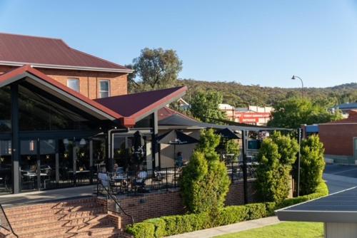 ToodyayVictoria Hotel Toodyay的一座带桌椅的庭院的建筑