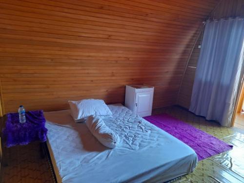 哥伦打洛省Pondok Wisata Botu Barani的卧室配有白色的床和木墙