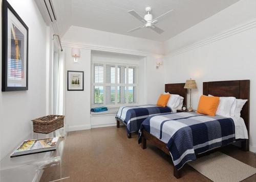 James CisternCoastal Haven: Charming Beachfront Cottage with Pool的一间卧室配有两张床和吊扇