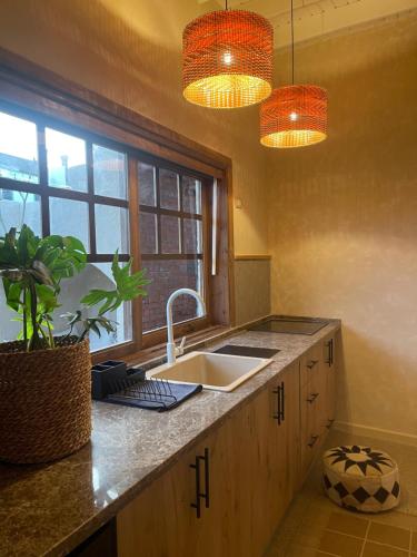 达哈布Mannam apartment boho的厨房设有水槽、窗户和2盏灯。