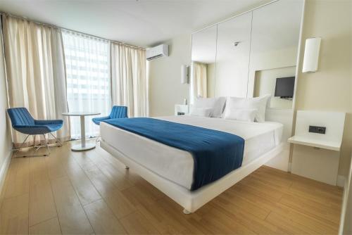 巴统ORBI CITY batumi的酒店客房带一张床、一张桌子和椅子