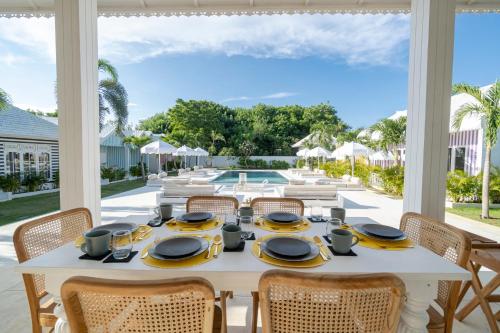 乌鲁瓦图Ria Uluwatu, Tropical Chic Hotel的一间设有桌椅的泳池景用餐室