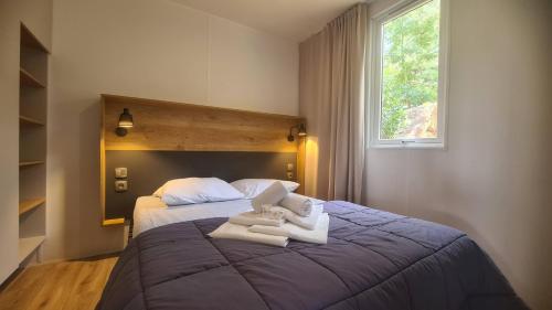 维琪奥港Vacances en Chalet ou Mobil-home chez Camp'in Pirellu的一间卧室配有一张大床和毛巾
