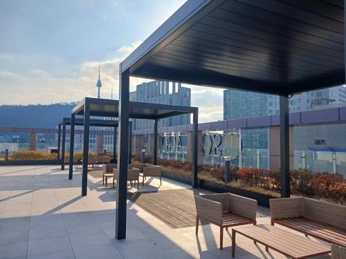 首尔INN-The City MyeongDong的大楼内带长凳和桌子的屋顶露台