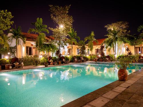 宁平Dong Ne Tam Coc Hotel & Resort的夜间在酒店前的游泳池