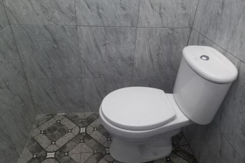 直葛OYO 93900 Guest House Cinta Damai的一间位于客房内的白色卫生间的浴室