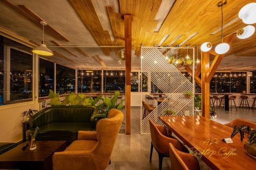 大叻Hera Hotel Đà Lạt的客厅配有绿色沙发和桌子