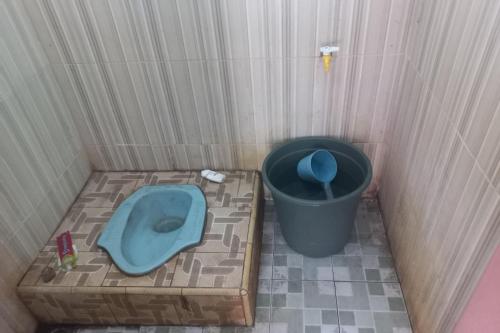 普禾加多SPOT ON 93917 Homestay Adreena Syariah的一间设有蓝色厕所和垃圾桶的小浴室