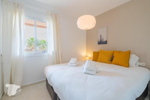 卡尔佩Zafiro的卧室配有一张带黄色枕头的大型白色床。