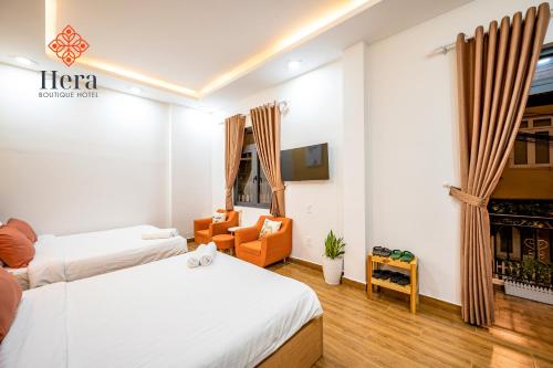 大叻Hera Hotel Đà Lạt的酒店客房,配有两张床和椅子