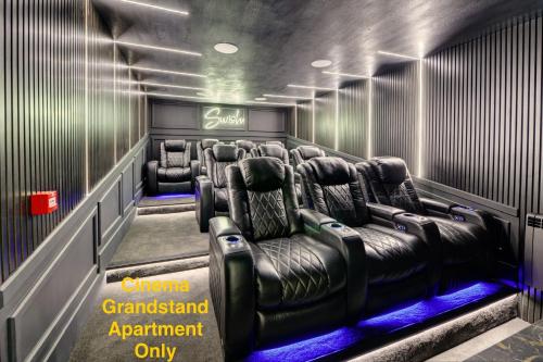 布莱克浦Swish Luxury Holiday Apartments的电影室,配有皮椅和标志,显示电影台的看台只有预约