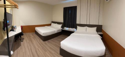 怡保T SQUARE HOTEL (IPOH)的酒店客房配有两张床和一张书桌