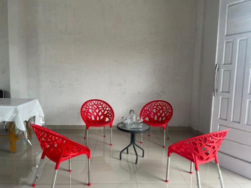 棉兰OYO 93947 Bahagia Guest House的房间里的四把红色椅子和一张桌子