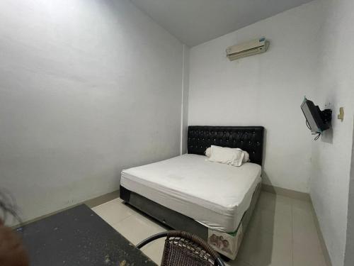 棉兰OYO 93947 Bahagia Guest House的小房间设有床铺和电视