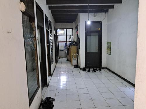 万隆SPOT ON 93956 Siliwangi Guest House Syariah的一条空的走廊,有门,铺着瓷砖地板