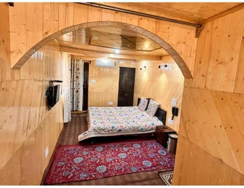 古尔马尔格Hotel Nagview Cottage, Jammu and Kashmir的木制客房内的一间卧室,配有一张床