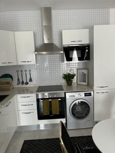 阿克拉The Lennox by Luxe Properties的厨房配有洗衣机和白色橱柜。