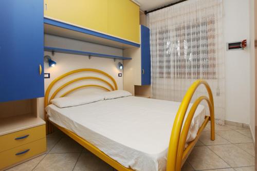 罗索利纳马雷Villa Zanella的一间卧室配有一张黄色和蓝色床头板的床