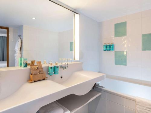 巴涅奥莱诺沃特巴黎东部酒店的白色的浴室设有水槽和浴缸。