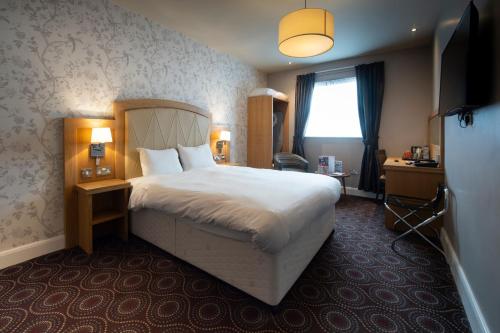 亨廷登桑福德豪斯威瑟斯本酒店的一间设有大床和窗户的酒店客房