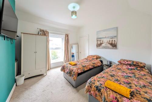 伯恩茅斯Town Centre House for 6 Guests的一间卧室设有两张床和窗户。