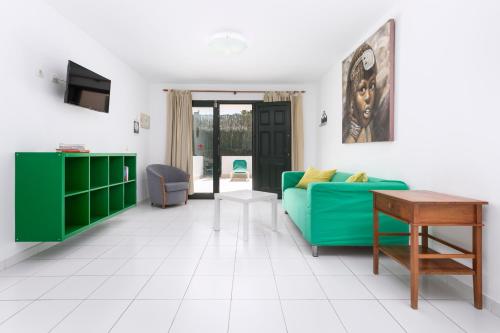 科拉雷侯Apartamentos Erika - Adults Only的客厅配有绿色沙发和桌子