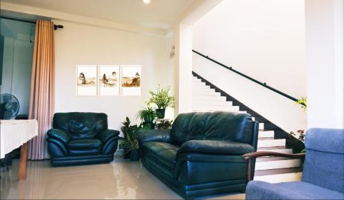 卡卢特勒Ananthaya -the infinity的客厅设有两张皮椅和楼梯
