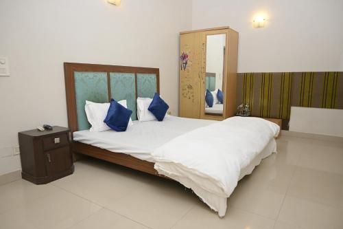 新德里ownstay chhatarpur的一间卧室配有一张带蓝色枕头的大床