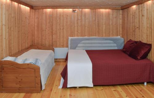 EnhörnaAmazing Home In Enhrna With Sauna的木镶板客房内的一间卧室配有两张床