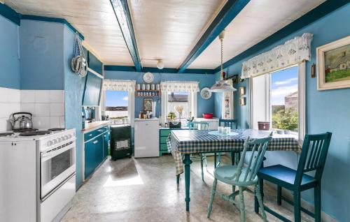 SætraCozy Home In Norddyry With Kitchen的厨房拥有蓝色的墙壁,配有桌椅