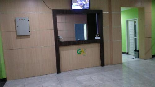 明古鲁省Hotel Grand Atlet Bengkulu的一间设有墙壁的房间,里面配有电视