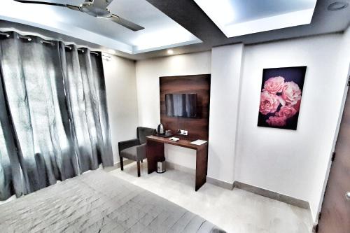 新德里Hotel Delhi Aerocity, NH 8的一间房间,配有一张桌子和一把挂着鲜花的椅子