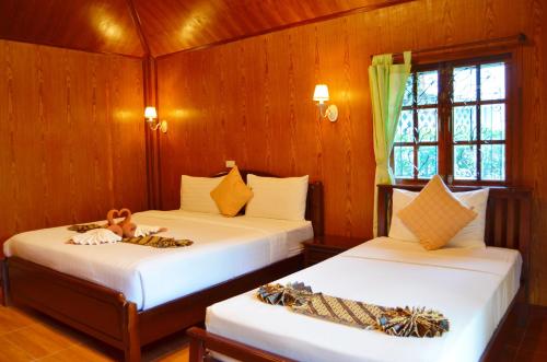 高兰高兰沙洋海滨度假酒店 的木墙客房的两张床