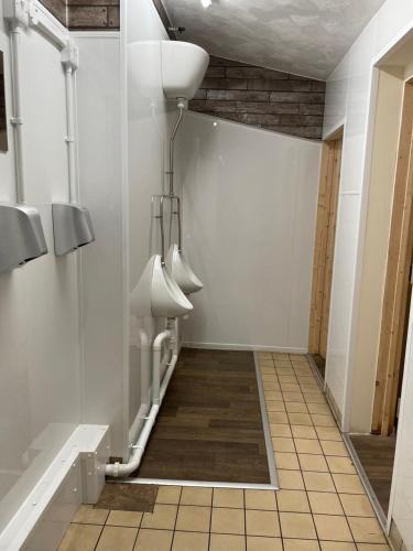 CinderfordThe New Inn的一间白色墙壁和白色小便器的浴室