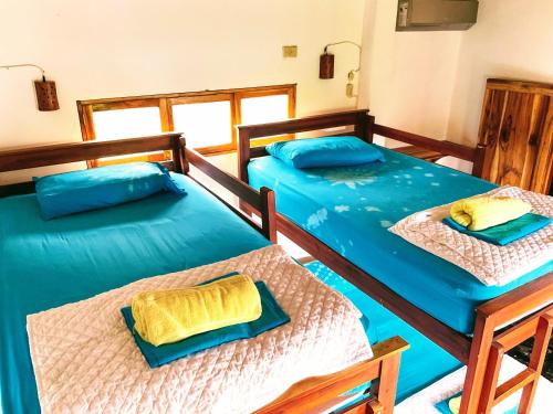 Las TunasHermanos Perdidos Surf的配有蓝色床单的客房内的两张床