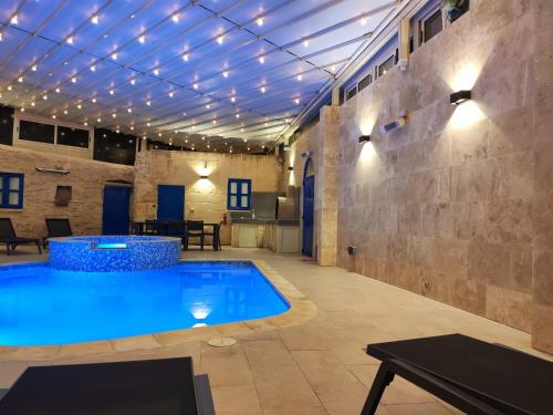QrendiMargerita Farmhouse的一个带灯光天花板的房间的游泳池