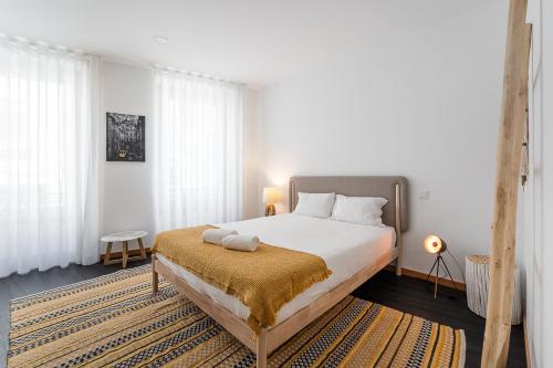 波尔图GuestReady - Bright Duplex in Downtown的一间卧室配有一张带黄色毯子的大床