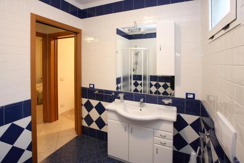 罗索利纳马雷Villa Medea的浴室设有水槽和蓝色及白色瓷砖