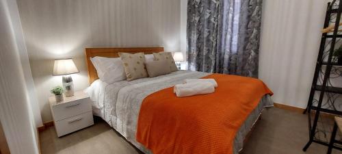 丰沙尔Vista City的一间卧室配有一张带橙色毯子的床
