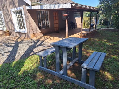 霍维克Siesta Cottage的房屋前的野餐桌和长凳