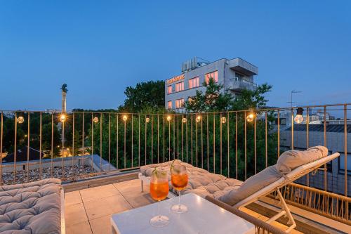 波尔图GuestReady - Top floor lodge with a stunning view的阳台的天井配有桌子和2杯饮品