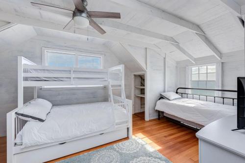Wakefield6.5-Acre Oceanfront Estate的白色客房 - 带两张双层床和吊扇