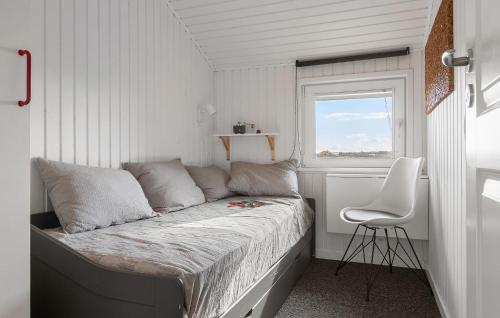 约灵Gorgeous Home In Hjrring With House A Panoramic View的一间小卧室,配有一张床和一把椅子