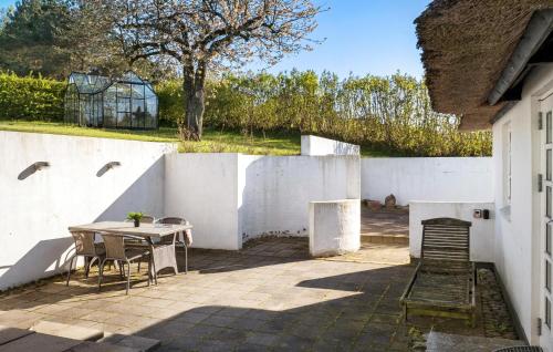 Hårby2 Bedroom Cozy Home In Haarby的白色围栏旁的庭院配有桌椅