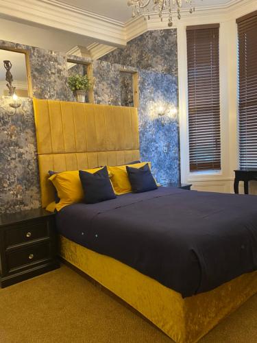 绍斯波特The New Talbot Hotel的一间卧室配有一张大床,提供黄色和蓝色的枕头