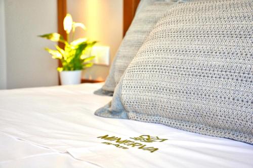 AlepochórionMinerva Estate Corfu的枕头坐在床边的床上