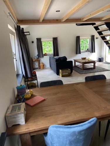 HelvoirtOp den Distelberg的一间带木桌的用餐室和一间客厅。